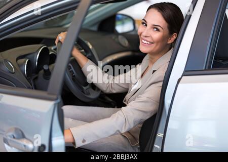 Junge Frau im Autoshowroom Stockfoto