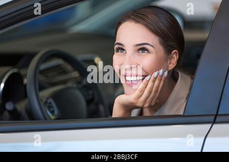 Junge Frau im Autoshowroom Stockfoto