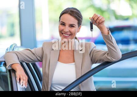 Junge Frau im Autoshowroom Stockfoto