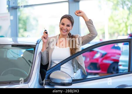 Junge Frau im Autoshowroom Stockfoto