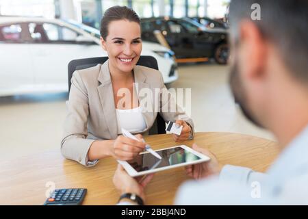 Junge Frau im Autoshowroom Stockfoto