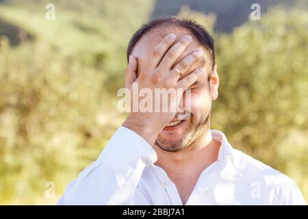 Lächeln Gesicht Palmenmann in einem weißen Hemd in der Natur Stockfoto