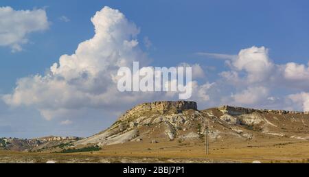 Große Cumulus-Wolke über dem Weißen Felsen (AK-Kaya) auf der Krim. Abendlicht Stockfoto