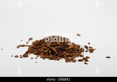 Nahaufnahme von Granulat aus granuliertem Instantkaffee, weißer Hintergrund Stockfoto