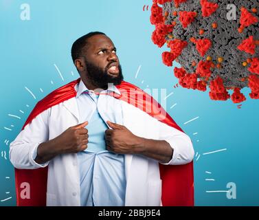 Medic agiert wie ein Superheld zur Bekämpfung der Pandemie von Kovid19-Coronaviren. Blauer Hintergrund Stockfoto