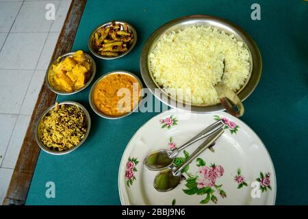 Schüssel mit weißem Reis mit verschiedenen vegetarischen Currys - traditionelles Essen zum Mittagessen. Vegetarischer Reis und Curry im Café auf dem Tisch. Sri Lanka Stockfoto