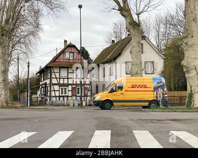 Straßburg, Frankreich - 4. März 2020: Blick auf die elsässische Straße mit neuem gelben Mercedes Benz Lieferwagen mit DHL Deutsche Post Logo Stockfoto