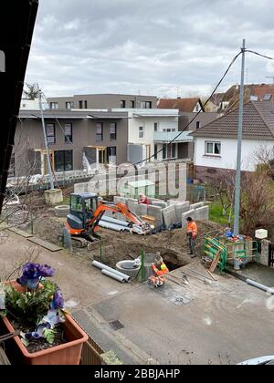 Paris, Frankreich - 14. Februar 2020: Arbeiter der Baustellenanlage mit Deckenansicht und Hitachi Bagger in der Nähe neuer Gebäude für Immobilienwohnungen Stockfoto