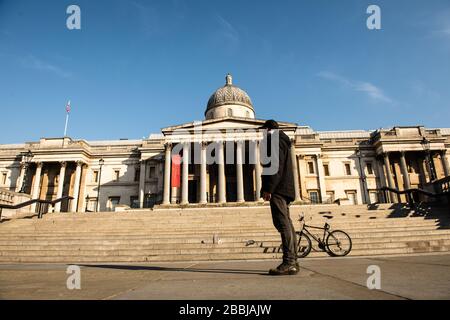 Ein einiger Mann steht am Trafalgar Square, London, England. Stockfoto