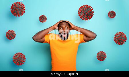 Ängstlicher Ausdruck eines Jungen, der Angst hat, das Coronavirus zu fangen. Hintergrund Zyan. Stockfoto