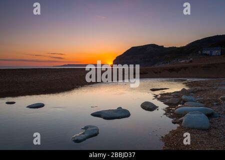 Seatown, Dorset, Großbritannien. März 2020. Wetter in Großbritannien. Der Sonnenuntergang vom Strand in Seatown in Dorset aus gesehen, während der Himmel am Ende des Tages auf die Klippen von Golden Cap blickt. Bildnachweis: Graham Hunt/Alamy Live News Stockfoto