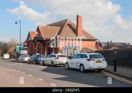 Taxis, die auf Passagiere vor dem Bahnhof in Poulton le Fylde Lancashire England Großbritannien warten. Stockfoto