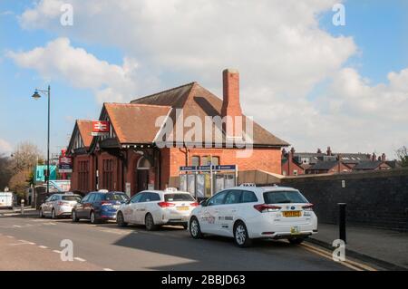 Taxis, die auf Passagiere vor dem Bahnhof in Poulton le Fylde Lancashire England Großbritannien warten. Stockfoto