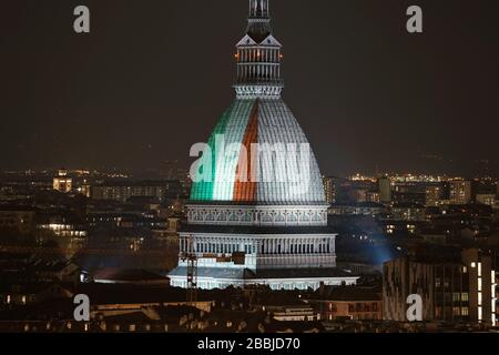 Die Mole Antonellana wird mit der italienischen Flagge beleuchtet, um an die vielen Opfer der Coronavirus-Pandemie zu erinnern. TURIN, ITALIEN - MÄRZ 2020 Stockfoto