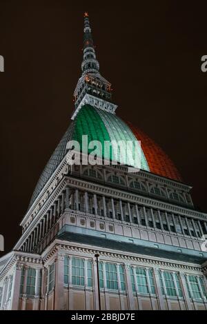 Die Mole Antonellana wird mit der italienischen Flagge beleuchtet, um an die vielen Opfer der Coronavirus-Pandemie zu erinnern. TURIN, ITALIEN - MÄRZ 2020 Stockfoto