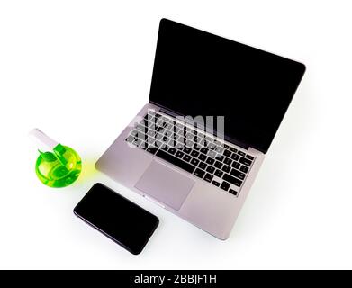 Desinfektionsflasche und Laptop isoliert auf weißem Hintergrund. Verhindern von Reinigungsarbeiten im Haushalt gegen Coronavirus Stockfoto