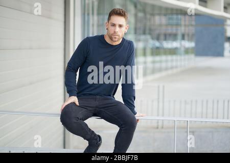 Niedriger Winkel der modernen Millennial männlich in lässigem Outfit mit Laptop Tasche l Stockfoto