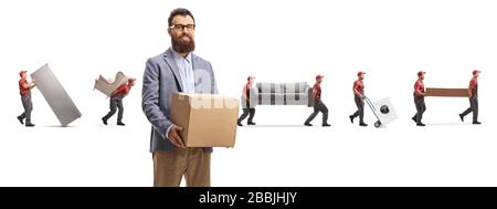 Bärtiger Mann, der einen Pappkarton hält, und Arbeiter, die Hausapplikationen und Möbel im Rücken tragen, isoliert auf weißem Hintergrund Stockfoto