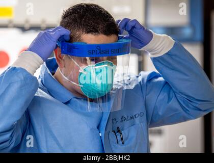 U.S. Navy Hospital Corpsman 3. Klasse Erick Galindo, dons ein Spritzschutz im Mikrolabor an Bord des Krankenhausschiffs USNS Mercy zur Unterstützung bei COVID-19, Coronavirus Pandemie Entlastung 30. März 2020 in Los Angeles, Kalifornien. Stockfoto