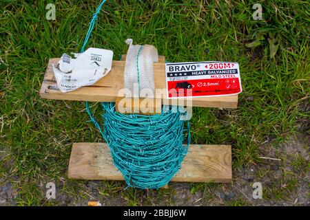 Stacheldraht wird als Sicherheitsumzäunung für die Kontrolle von Nutzvieh in einer Bauernhof-Umgebung verwendet. Stockfoto