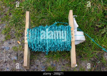 Stacheldraht wird als Sicherheitsumzäunung für die Kontrolle von Nutzvieh in einer Bauernhof-Umgebung verwendet. Stockfoto