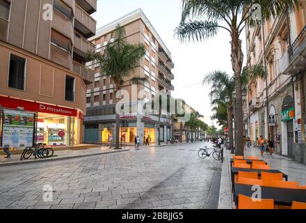 Geschäfte an der Hauptstraße Corso Umberto, wie die Einheimischen am frühen Abend spazieren, oder Passeggiata, in Brindisi Italien, in der Region Apulien genießen. Stockfoto