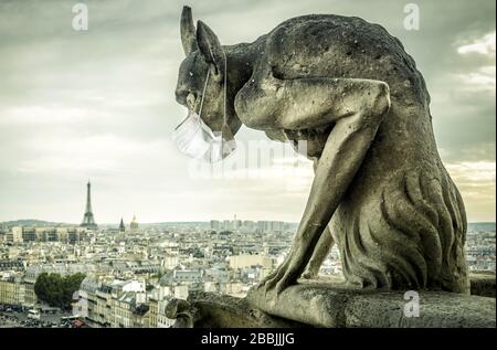 COVID-19 Coronavirus in Frankreich, medizinische Maske auf Wasserspeier von Notre Dame in Paris. Touristenattraktionen wegen des Ausbruchs des Corona-Virus geschlossen. Konzept des tra Stockfoto