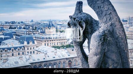 COVID-19 Coronavirus in Frankreich, medizinische Maske auf Wasserspeier von Notre Dame in Paris. Touristenattraktionen wegen des Ausbruchs des Corona-Virus geschlossen. Konzept des tra Stockfoto