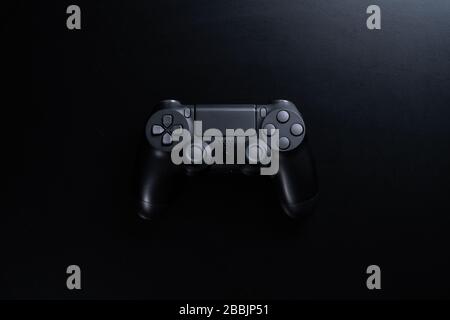 Ein schwarzer Gamecontroller, isoliert auf schwarzem Hintergrund. Stockfoto