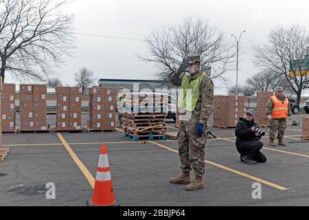 März 2020, Cleveland, Ohio, USA. Die größere Drive-Thru-Speisekammer der Cleveland Ohio Food Bank diente einer beispiellosen Anzahl von Menschen. Über einen Zeitraum von vier Stunden wurden in der Lebensmittelverteilung ca. 2.765 Familienanfälle angeboten, was 6.636 Personen entspricht, von denen 36 % zuvor noch nie in einer Notaufnahme waren. Laut der Greater Cleveland Food Bank haben sie in ihrer 40-jährigen Geschichte nie so viel Essen gegeben. Die Zahlen der letzten Wochen waren so hoch, dass sie den Standort in das Muni Lot verschoben, wo es von der Food Bank, der Ohio National Guard, der Ohio Military Reserve und der Cleveland Police besetzt wurde Stockfoto