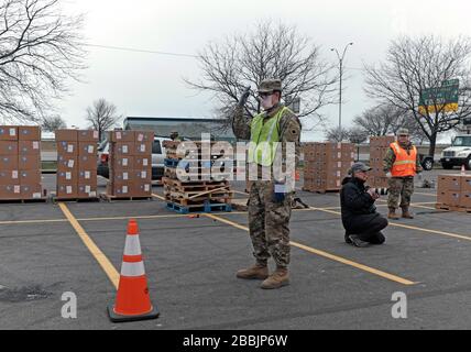 März 2020, Cleveland, Ohio, USA. Die größere Drive-Thru-Speisekammer der Cleveland Ohio Food Bank diente einer beispiellosen Anzahl von Menschen. Über einen Zeitraum von vier Stunden wurden in der Lebensmittelverteilung ca. 2.765 Familienanfälle angeboten, was 6.636 Personen entspricht, von denen 36 % zuvor noch nie in einer Notaufnahme waren. Laut der Greater Cleveland Food Bank haben sie in ihrer 40-jährigen Geschichte nie so viel Essen gegeben. Die Zahlen der letzten Wochen waren so hoch, dass sie den Standort in das Muni Lot verschoben, wo es von der Food Bank, der Ohio National Guard, der Ohio Military Reserve und der Cleveland Police besetzt wurde Stockfoto