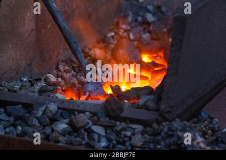 Schmied Ofen mit glühenden Kohlen, Tools und glühenden Metall Werkstücke Stockfoto