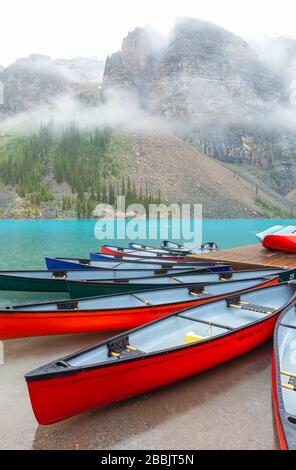 Bunte Kanus am Moraine Lake, Banff National Park, Alberta, Kanada, an einem Regensommertag. Stockfoto