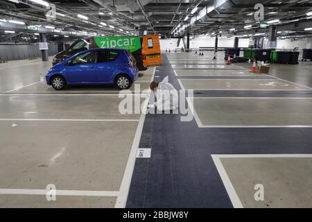 (200401) -- LONDON, 1. April 2020 (Xinhua) -- EIN Freiwilliger markiert Stellplätze für Lieferfahrzeuge an einem Verteilerknotenpunkt in der Tiefgarage am Tottenham Hotspur Stadium in London, Großbritannien, 31. März 2020. Der Verteilerknotenpunkt wurde von der Wohltätigkeitsorganisation Eßable London eingerichtet, die in Zusammenarbeit mit dem Haringey Council für die Verteilung von Lebensmitteln an schutzbedürftige Gruppen und Mitarbeiter des National Health Service (NHS) arbeitete. Die britische Regierung versucht weiterhin, den COVID-19-Ausbruch zu bekämpfen, während lokale Behörden, Gemeindegruppen und Wohltätigkeitsorganisationen daran arbeiten, Lebensmittel für die am meisten Sicherheitslücken bereitzustellen Stockfoto