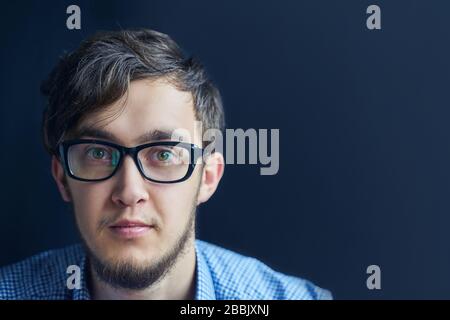 Mann in Brille. Der Kerl sieht in der Brille überraschend auf die Kamera. Stockfoto