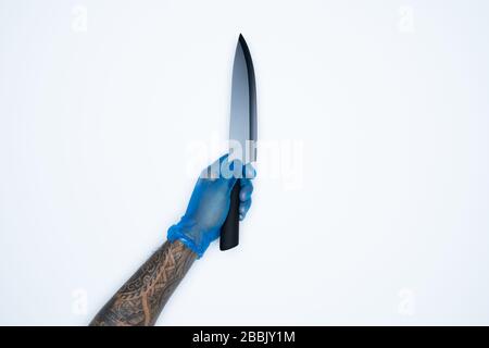 Ein Mann und Gesten in blauem Gummihandschuh zeigen Messer isoliert auf weißem Hintergrund. Stockfoto