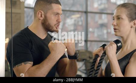 Ausbilder schreien bei Frauen, während sie im Fitnessstudio trainieren Stockfoto