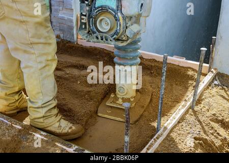 Vibrierender Hammer, springender Jack Machine kleiner Plattenkompakteur auf städtischen Gehwegen Stockfoto