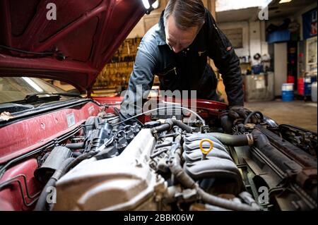 Berlin, Deutschland. März 2020. Andreas Lemmer, Automechaniker und Inhaber seiner Werkstatt, arbeitet an einem Auto. Credit: Fabian Sommer / dpa / Alamy Live News Stockfoto