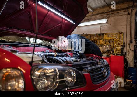 Berlin, Deutschland. März 2020. Andreas Lemmer, Automechaniker und Inhaber seiner Werkstatt, arbeitet an einem Auto. Credit: Fabian Sommer / dpa / Alamy Live News Stockfoto