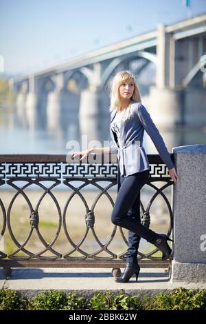 Junge Frau in der Stadt Nowosibirsk mit Brücke und Fluss im Hintergrund Stockfoto