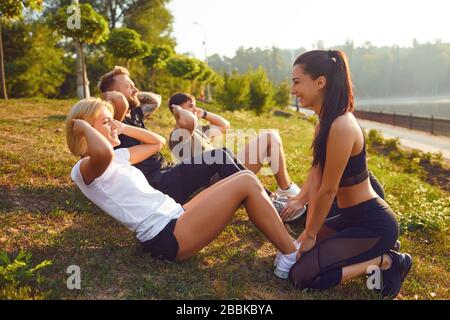 Eine Gruppe von Leuten, die Übungen im Park sitzen Stockfoto