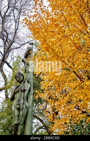 Gelber Ginkgo-Baum mit schöner Skulptur im Hintergrund Stockfoto