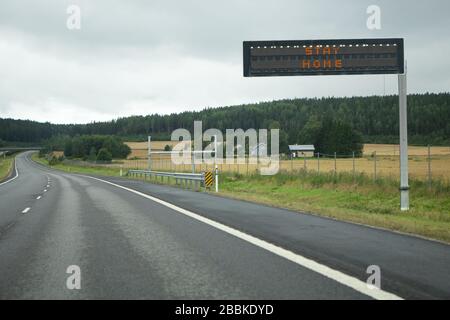 Autobahn mit Informationstafel. Bildunterschrift "zu Hause abhallt". Verbot der Bewegung in Quarantäne Stockfoto