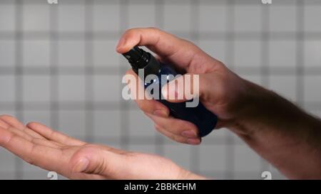 Man gibt Händededesinfektionsmittel in die Hände und desinfiziert sie. Stockfoto