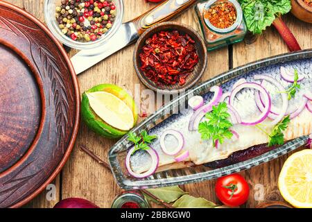 Gesalzene Heringe mit roter Zwiebel auf altem Holzhintergrund. Rustikale Küche Stockfoto