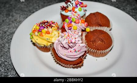 Nahaufnahme verschiedener süßer Cupcakes, selektiv fokussiert, vor einem bokehen Hintergrund Stockfoto