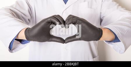 Arzt in medizinischen Handschuhen, zeigen Herzsymbol mit Hand in Seifenschaum isoliert auf weißem Hintergrund. Handhygiene Stockfoto