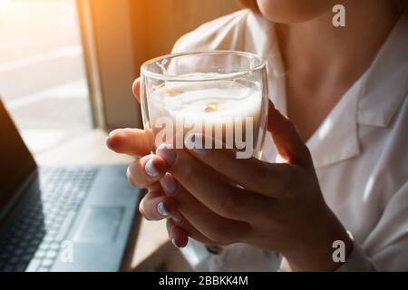 Das weibliche Modell hält eine Tasse Kaffee in der Hand. Nahaufnahme von Kaffee in der Hand Stockfoto