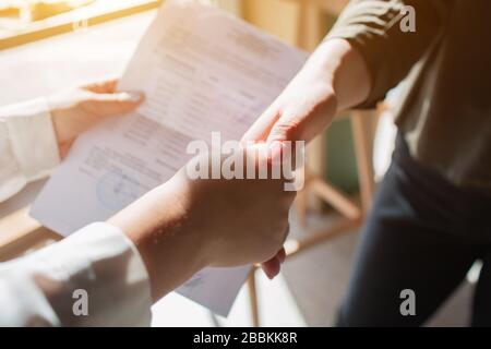 Nahaufnahme Handshake. Junge Frau hält ein Dokument in der Hand und macht einen Deal Stockfoto